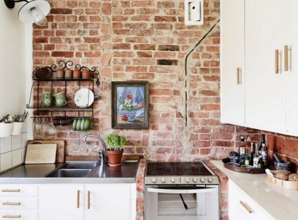 Dapur dengan dinding bata ekspos dan kabinet warna krem